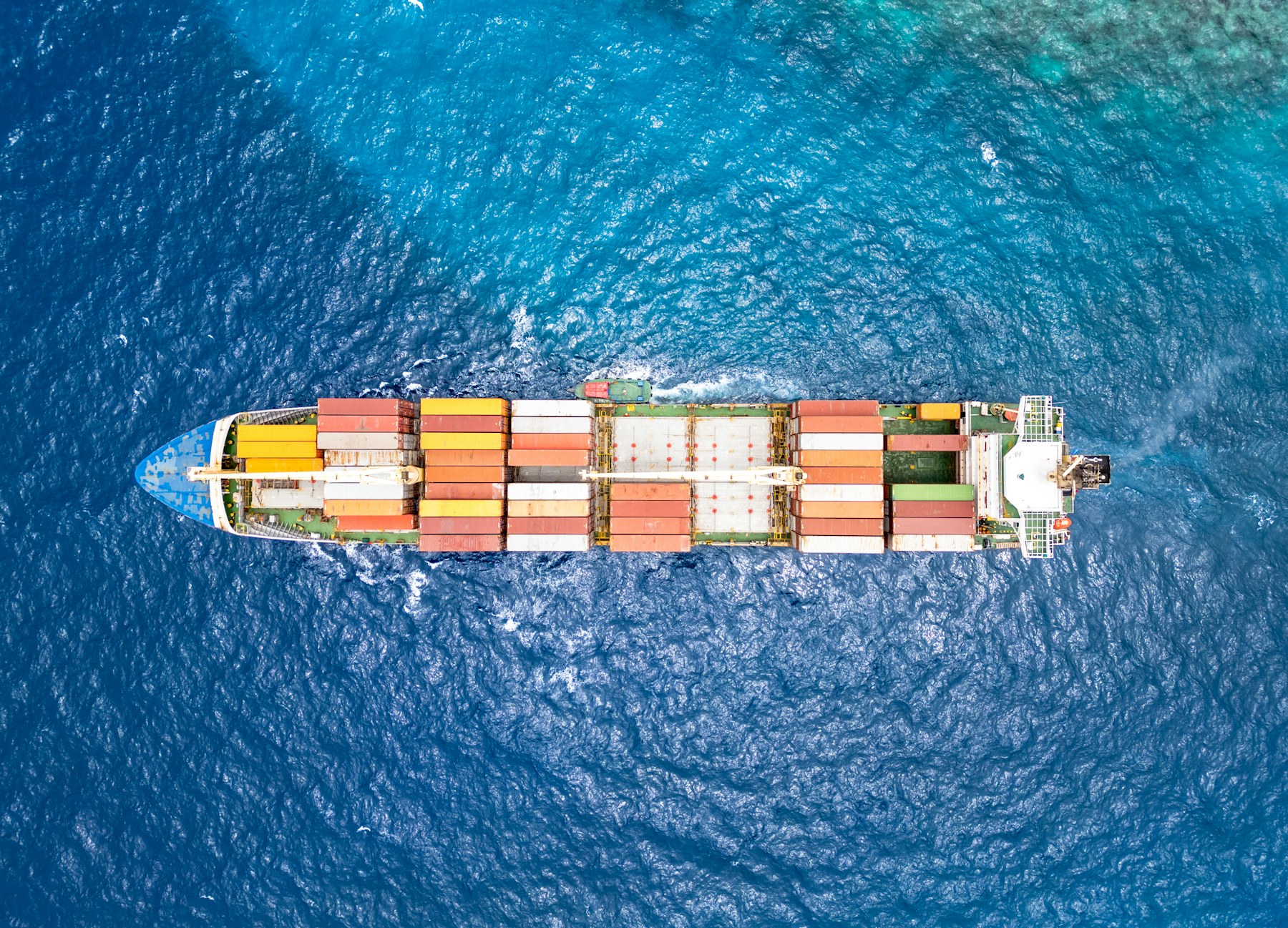 Container ship moving through open water on an international route
