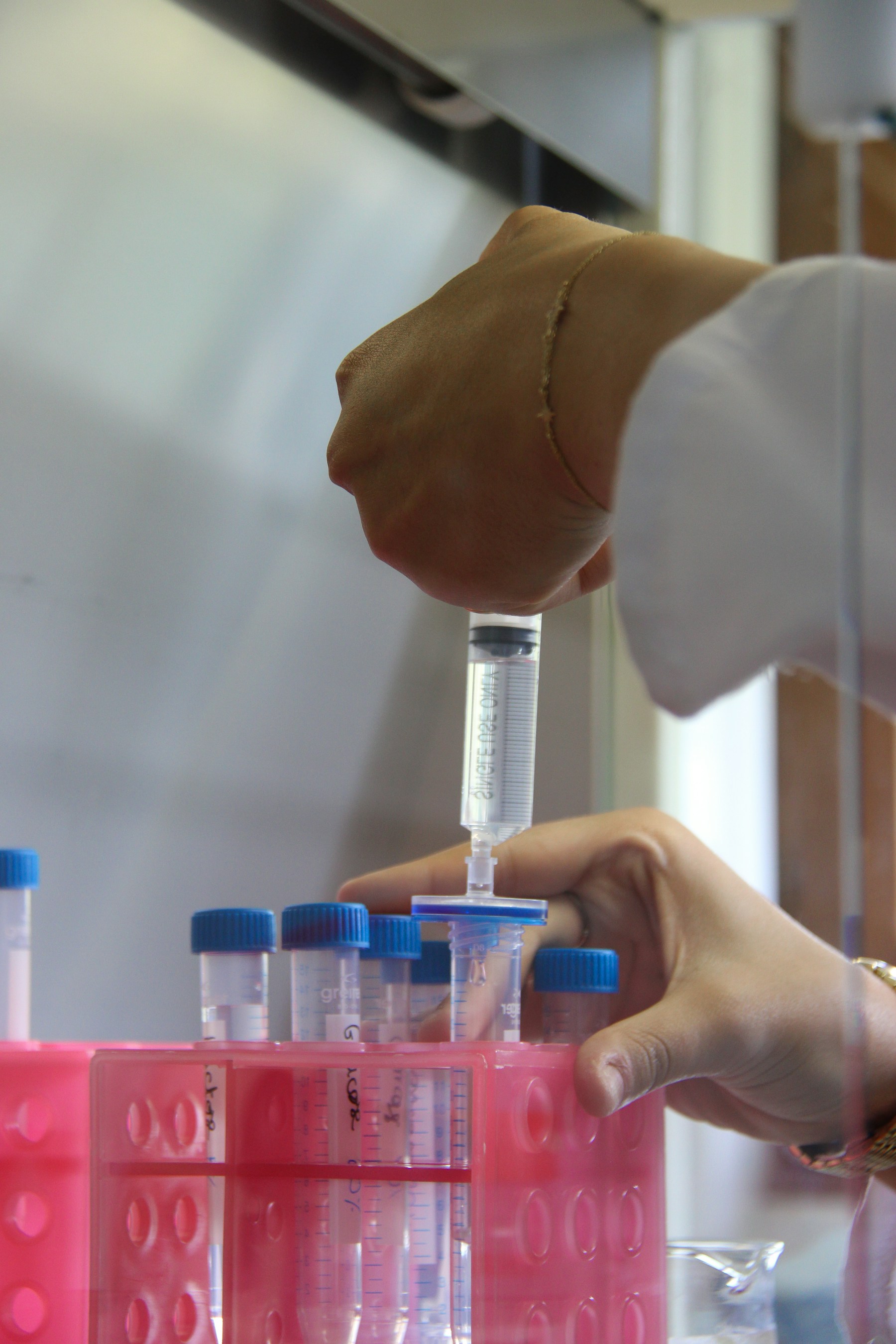 Laboratory technician preparing and filtering controlled samples