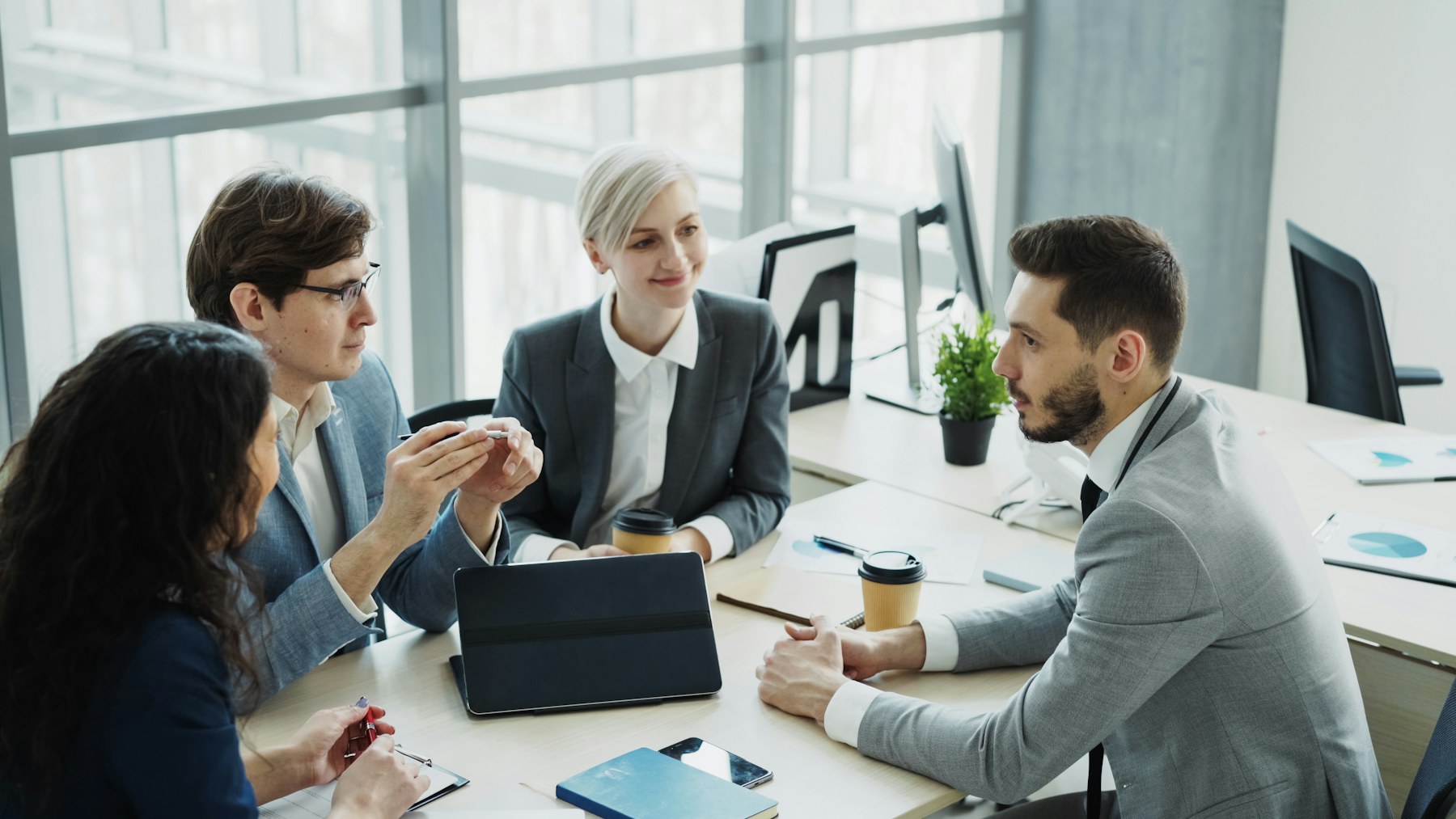 Commercial team collaborating around a table in a bright office